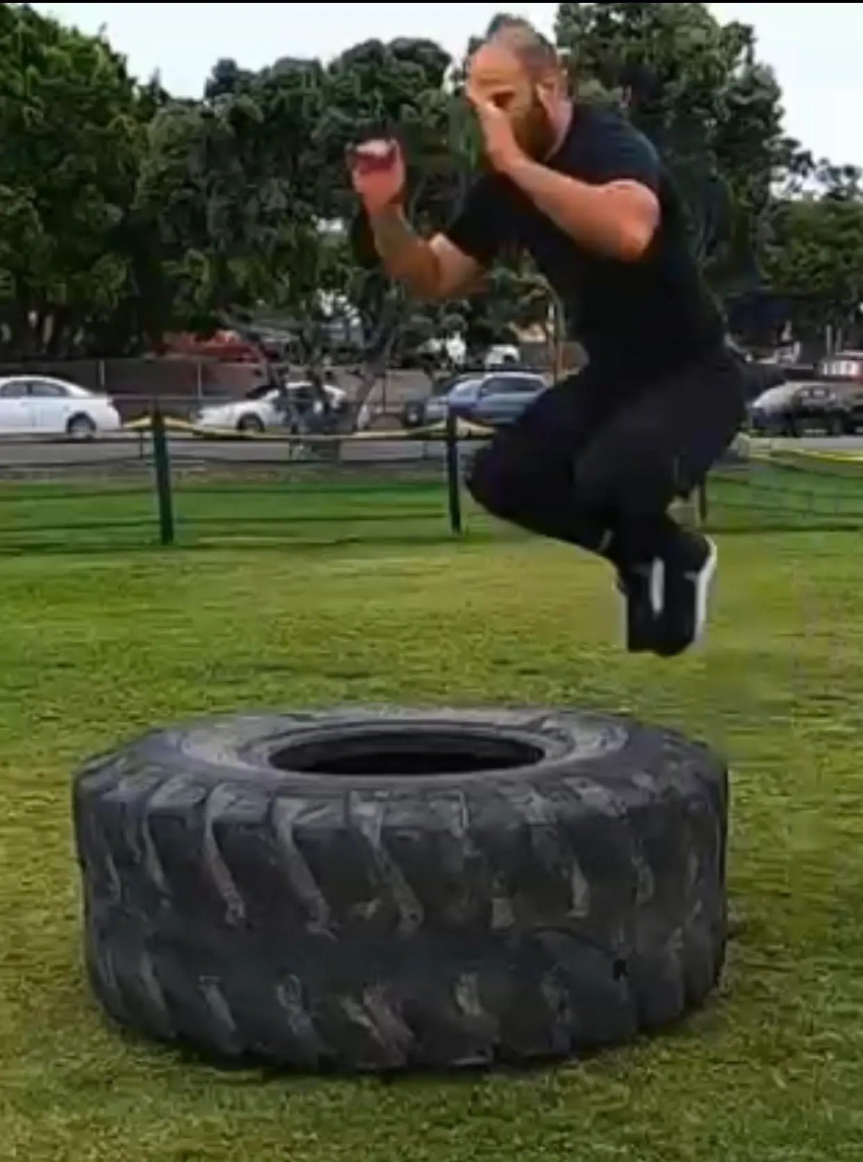 Gabriel jumping over a tire.